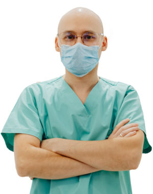 bald man with clear glasses wearing a blue face mask and teal scrubs crossing his arms